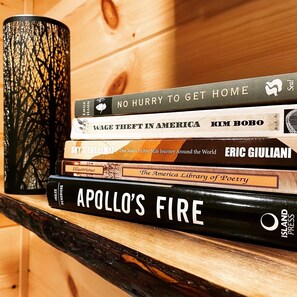 Una pila de libros sobre una estantería de madera.