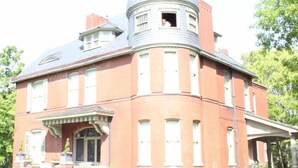 A large, historic building with a prominent dome and a corner turret.