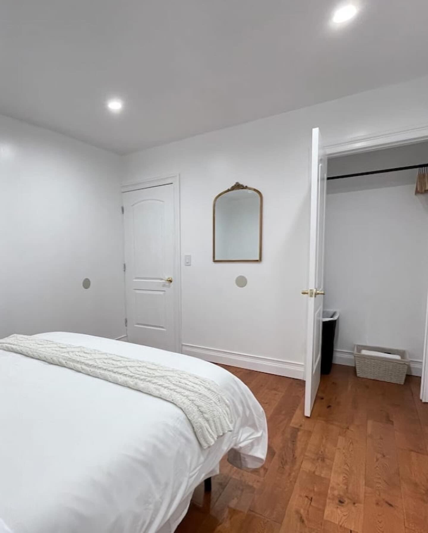 A bedroom with a bed, a wardrobe, and a mirror.