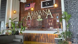 The interior of Arwana Resort with a reception desk, wooden panel walls, and hanging light fixtures. - Arwana Beach Resort - Perhentian (Pulau Perhentian Besar)