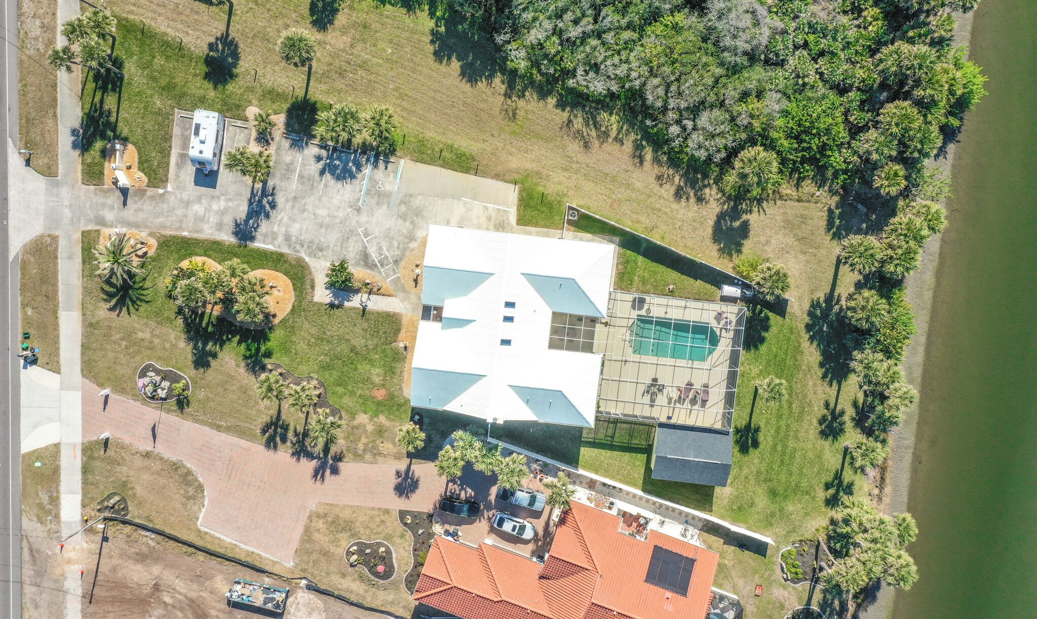 Vista aérea de un resort con una piscina grande, varias habitaciones de huéspedes y una zona de playa.