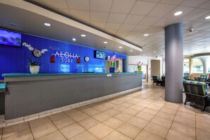 A reception area with a blue wall, a reception desk, and a clock.