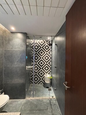 Een douche, handdoeken, zeep, toiletpapier