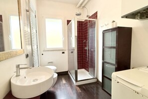 Un baño con un lavamanos grande, inodoro, ducha y un armario.