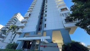 Un moderno edificio de gran altura con una escalera central, balcones y un letrero que dice "AMMANCH".