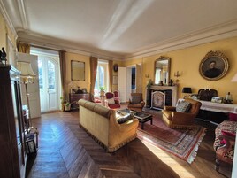 Una sala de estar tradicional con chimenea, un sofá, sillones y un comedor.