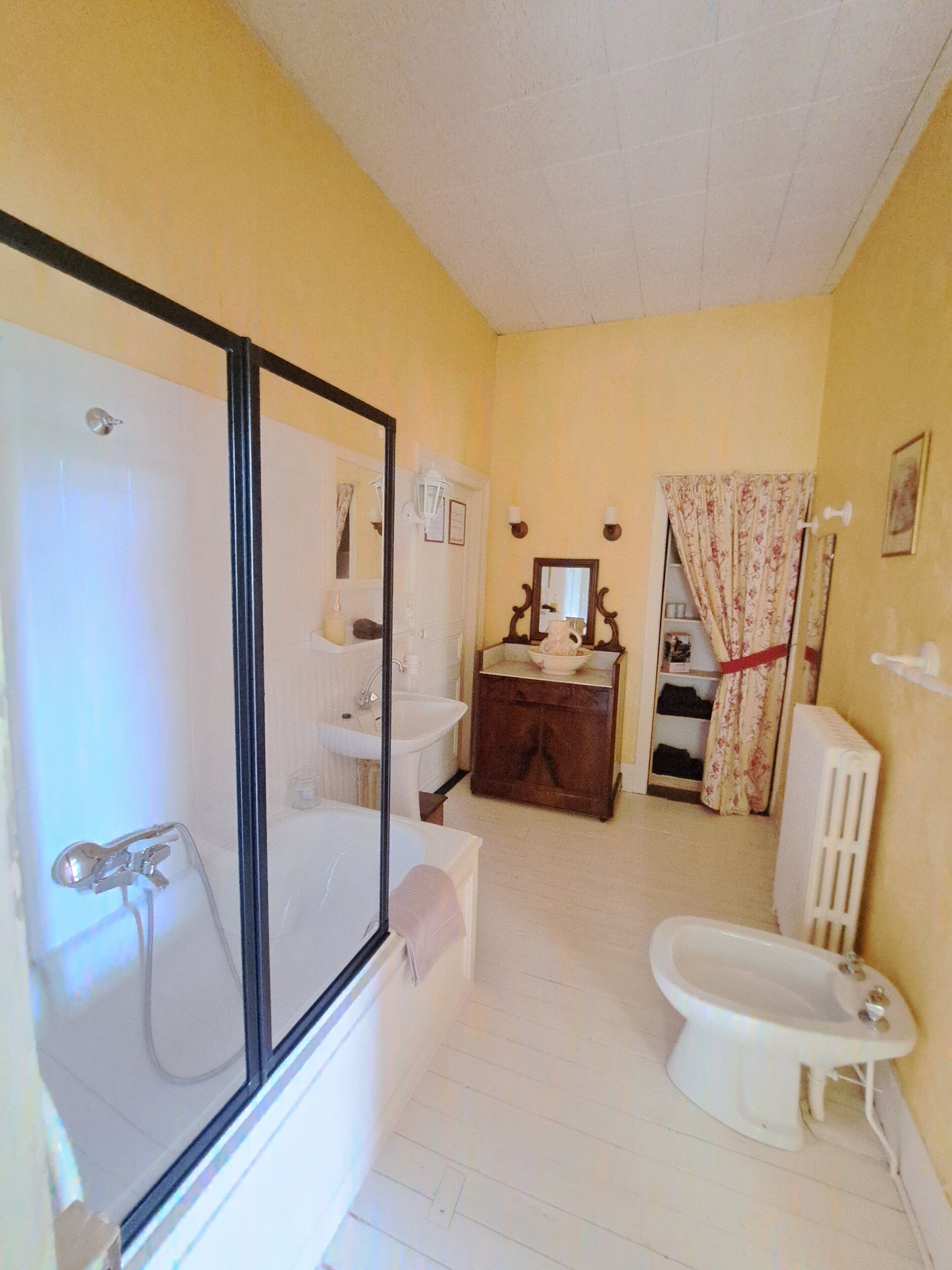 A bathroom with a bathtub, toilet, sink, and a mirror.