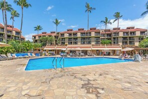 A hotel with a swimming pool, palm trees, and a clear blue sky. - South Kihei resort 1 bedroom condo, AC, across street from beach, walkable area (Wailea-Makena)