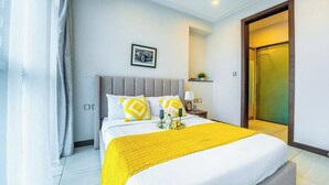 A hotel room with a bed, a nightstand, a framed picture on the wall, and a door to the right. - 2 Bedroom at Skynest Residency Westlands (Nairobi)