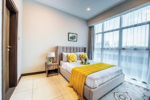 A hotel room with a bed, bedside table, and a large window with a view. - 2 Bedroom at Skynest Residency Westlands (Nairobi)