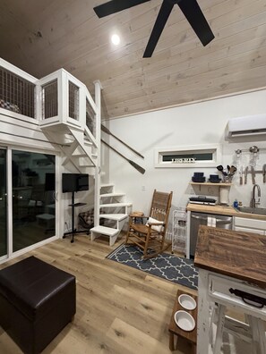 A modern kitchen with white cabinetry, a wooden dining table, and a built-in stove. - Pet-Friendly Table Rock Lake Cabin near Eureka Springs (Eagle Rock)