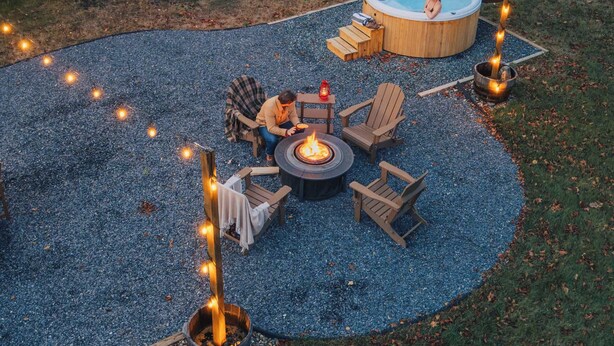 A backyard with a hot tub, fire pit, and outdoor seating.