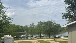 A grassy area with a grill, picnic table, and RV.