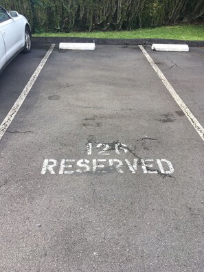 En parkeringsplads med et skilt, der viser '12 RESERVEREDE'.
