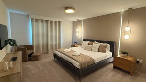 Una habitación de hotel moderna con una cama grande, un escritorio, una silla y una televisión.