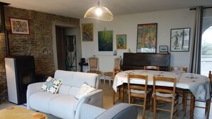 A cozy living room with a fireplace, a dining table, and a sofa.