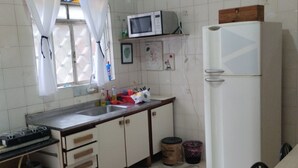 A kitchen with white cabinets, a microwave, a refrigerator, a gas stove, and a sink. - house with WiFi in Guarulhos you can share room and kitchen and hall with tv (Jardim Cristina Guarulhos)