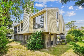 A two-story house with a sloped roof, large windows, and a fenced yard. - 3 BR/2BA home in So. Bethany (South Bethany)