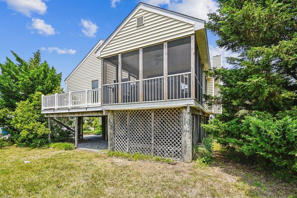 A two-story house with a balcony and a covered porch area.