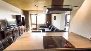 Cocina moderna con una isla central, electrodomésticos integrados y una zona de comedor con sofá.