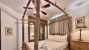 A four-poster bed with a wooden canopy, a bedside table with a lamp, and a framed picture on the wall. - Puerto Nuevo Villa Olas 2BR 2BA with pool (Centro Turístico El Pescador)
