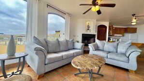 A living room with two grey sofas, a round coffee table, and a ceiling fan.