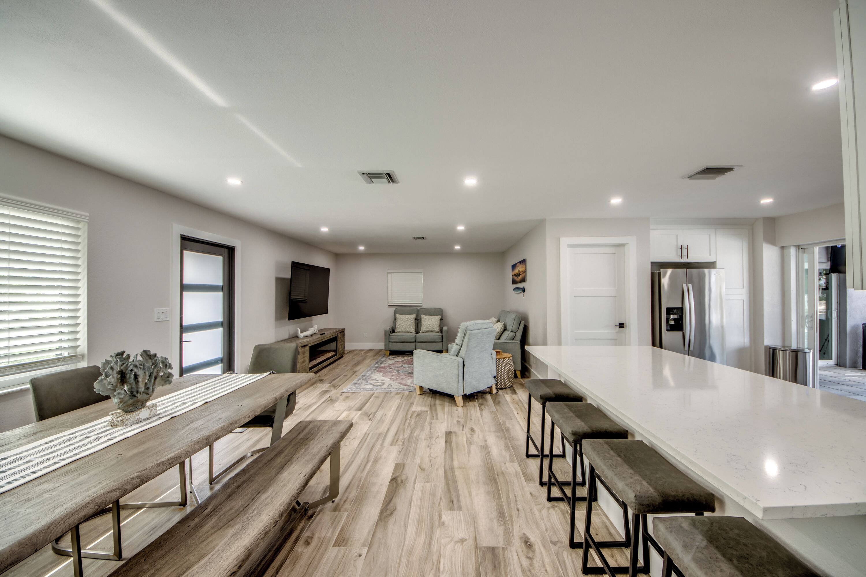 A spacious kitchen with a large island, wooden flooring, and modern appliances.