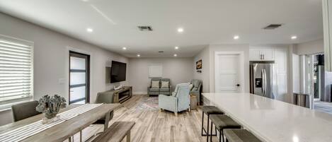 A spacious kitchen with a large island, wooden flooring, and modern appliances.