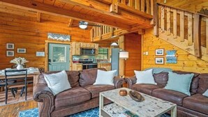 A log cabin interior with a dining area, a sofa set, a staircase, and a kitchen. - Beautiful Mountain View Cabin in Sevierville (Sevierville)