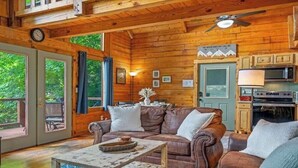 A wooden cabin interior with a dining area, a sofa, and a kitchen. - Beautiful Mountain View Cabin in Sevierville (Sevierville)