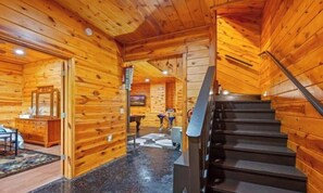 L’intérieur d’un chalet en bois comprend un escalier, un coin repas et une cuisine.