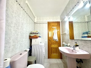 A bathroom with a toilet, sink, and mirror. There is a towel rack with towels and a door with a towel hanging on it. - 160m CHALET IN PEÑISCOLA, WITH PARKING AND POOL. NEAR THE BEACH. (Peníscola)