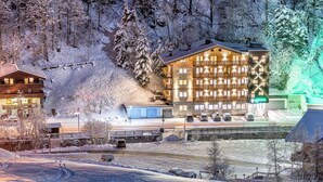 A hotel with multiple floors, balconies, and a ski slope nearby. - Siegmundshof Hotel Garni (Saalbach)