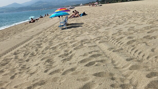 A wide sandy beach with a few people and umbrellas. - 2mns walk to beach, shops and entertainment, 2**apart 2pers, air-conditioned, large terrace. (Argelès-sur-Mer)