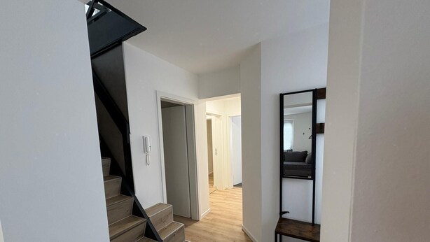 A staircase leading to a room with a wooden floor and a black metal railing. - Super nice and extremely large apartment approx. 145 m² in a country house in Priorei (Hagen)