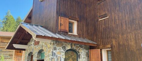 A multi-story wooden building with stone accents and wooden shutters.