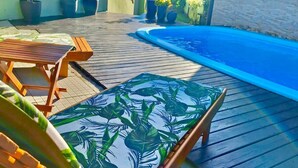 A wooden deck with a pool, outdoor furniture, and potted plants. - Chalés Santa Marta (Laguna)
