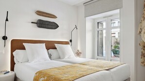 A double bed with a patterned throw, a wooden headboard, and two bedside lamps. - Ulia Terrace by FeelFree Rentals (San Sebastian)