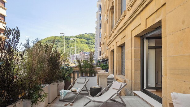 A rooftop terrace with two lounge chairs, a small table, and potted plants. - Ulia Terrace by FeelFree Rentals (San Sebastian)