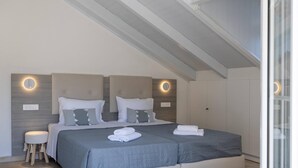 Ein Schlafzimmer mit einem großen Bett, zwei Nachttischen und einer Decke mit sichtbaren Holzbalken.