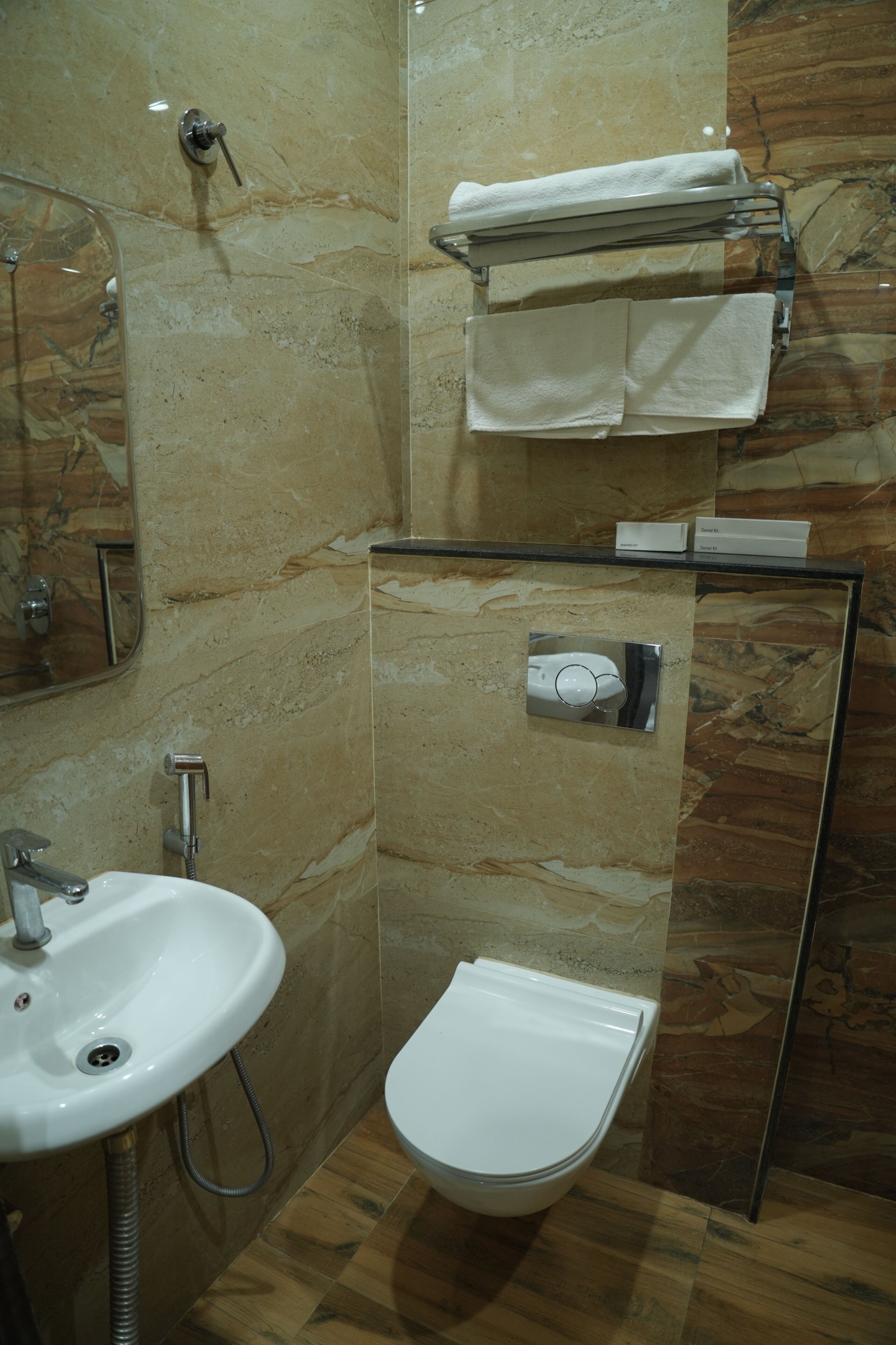 A bathroom with a sink, toilet, towel rack, and a mirror.