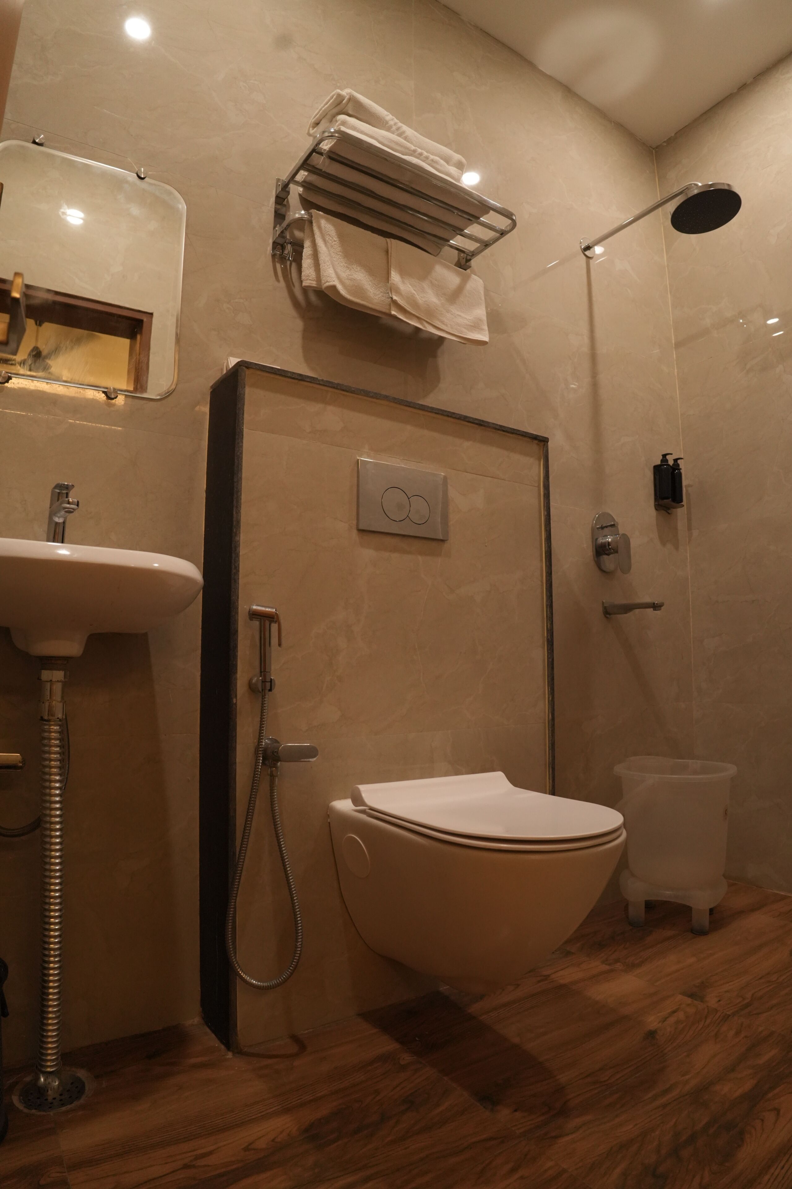 A bathroom with a sink, toilet, shower, and towel rack.