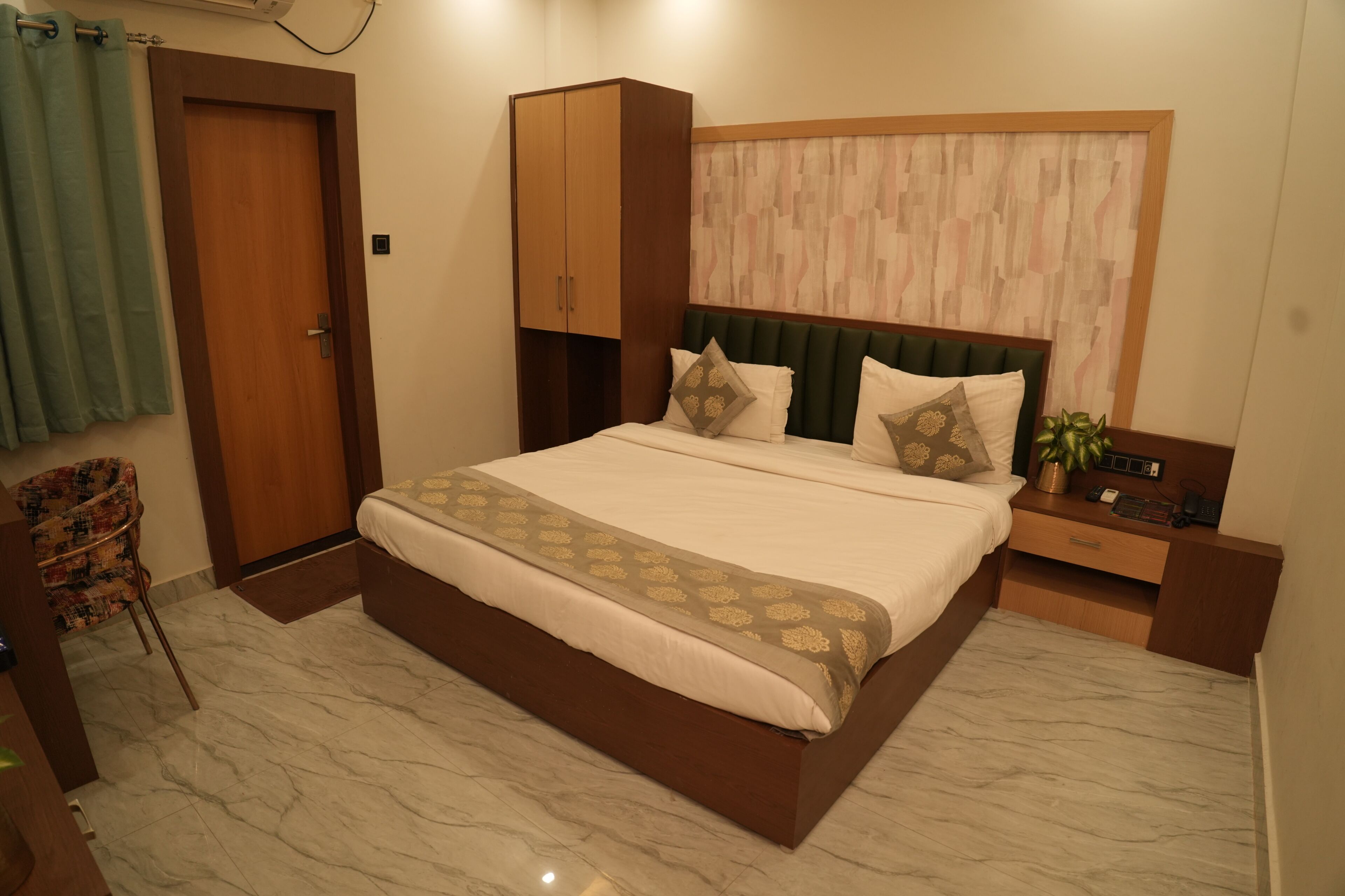 Une chambre à coucher comprenant un lit, une armoire, une table de chevet et une chaise.