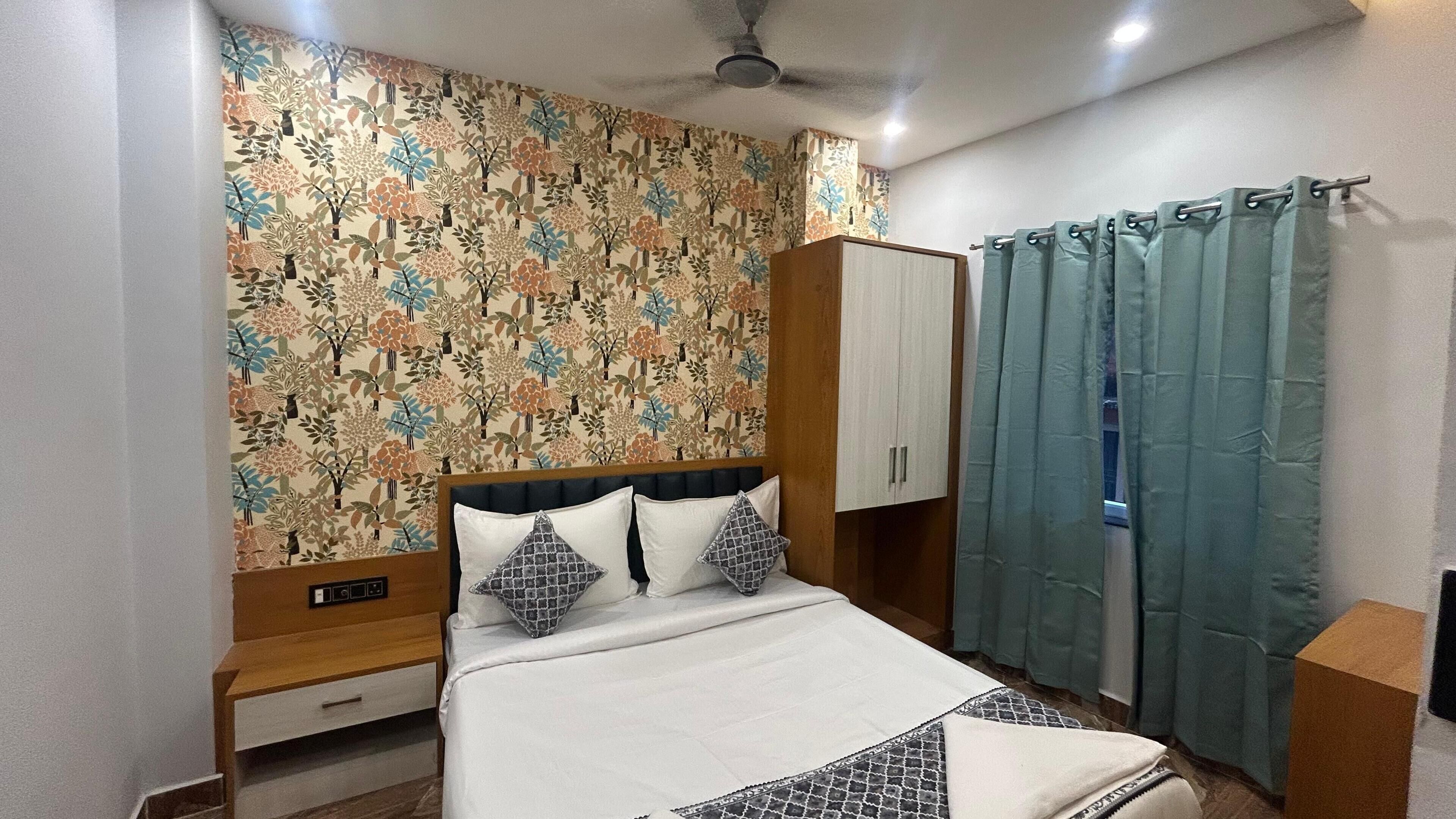 A bedroom with a bed, a wardrobe, a nightstand, and a curtain.