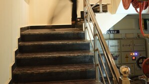 A staircase with a poster of a temple and a sign for Hotel Sahu. - SANIDHYAM by HOTEL SAHU (Varanasi)