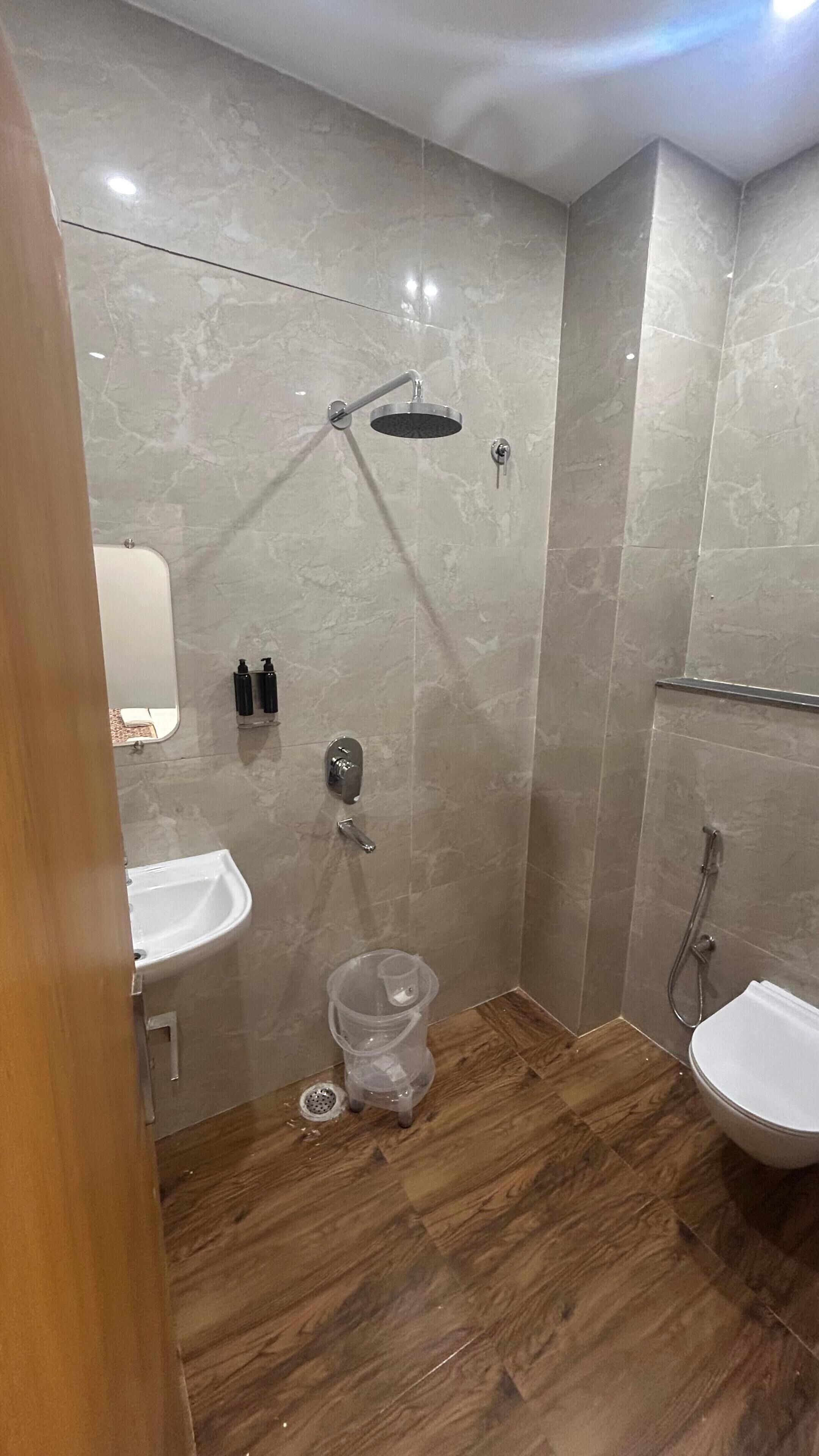 A modern bathroom with a shower, sink, and toilet.