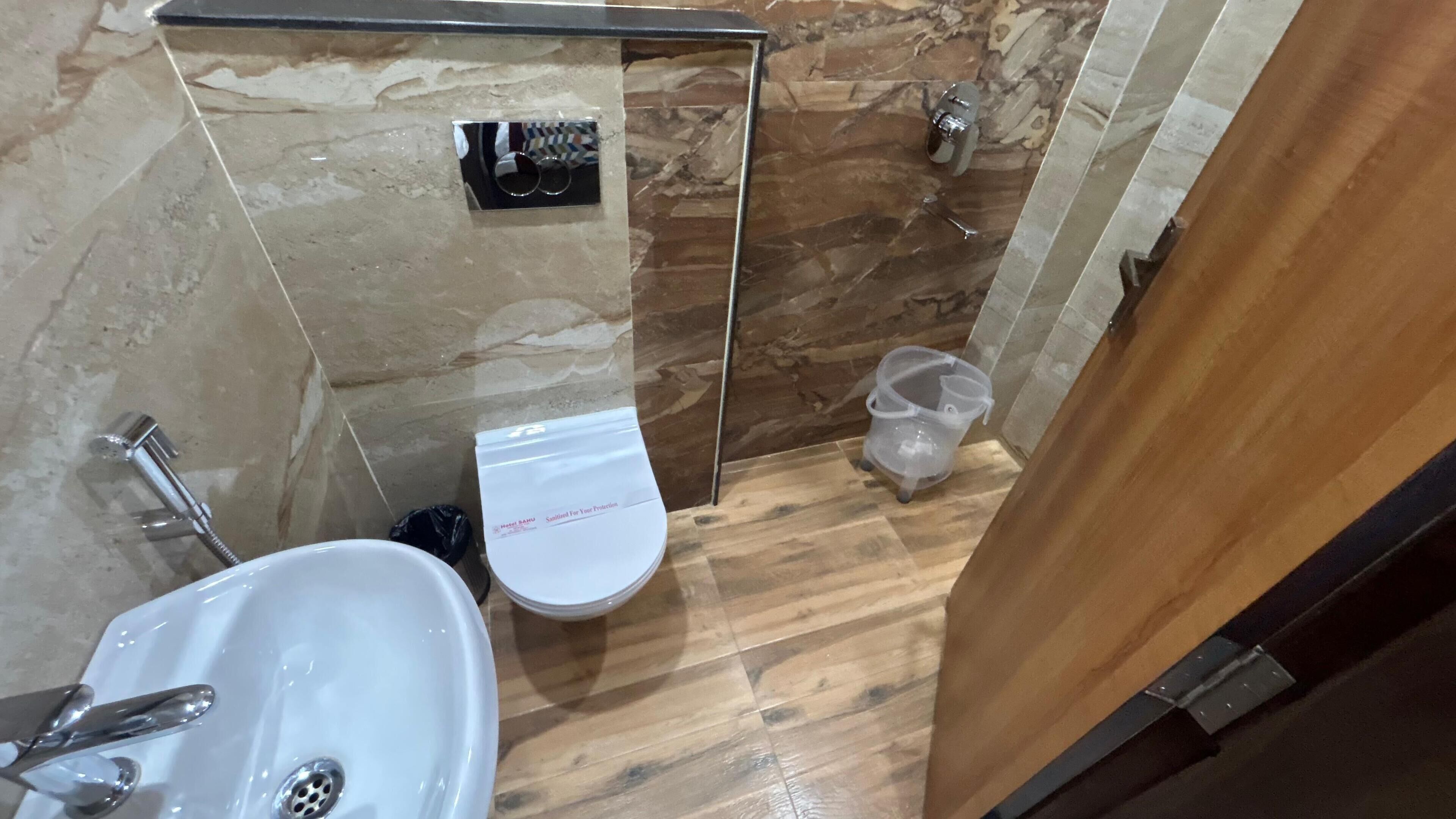 Une petite salle de bain avec un lavabo, des toilettes et une douche, le tout de couleur blanche.