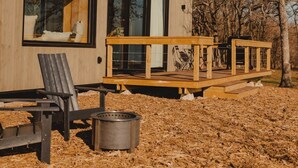 A modern cabin with large windows, a deck, and outdoor seating. - Wilding Hotels Scenic Suite (West Tawakoni)