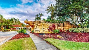A landscaped area with a rock formation labeled "terra firma" and a pathway leading to a building. - Spacious, 7R, 4.5BA Pool/Spa Home With Outside Covered Seating Area (166) (Kissimmee)
