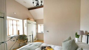 A bedroom with a bed, a tray with breakfast, a window, and a wardrobe. - The Stone Barn - Luxury Barn in Rural Wiltshire (Studley)